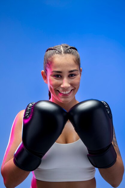 Femme souriante de coup moyen avec des gants