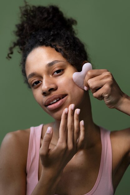 Femme souriante à coup moyen avec gua sha