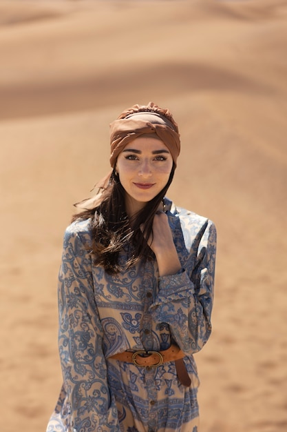 Femme souriante à coup moyen portant un foulard sur la tête