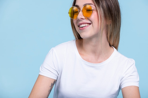 Photo gratuite femme souriante à coup moyen portant des lunettes de soleil