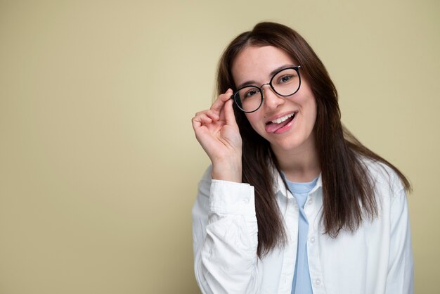 Femme souriante à coup moyen portant des lunettes en studio
