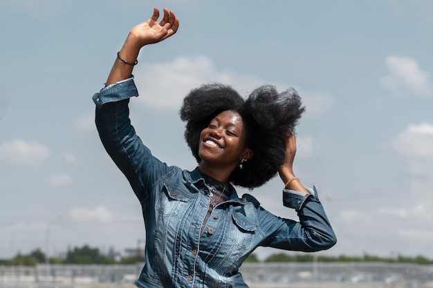 Femme souriante à coup moyen posant à l'extérieur