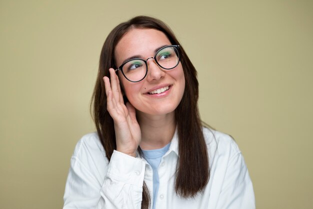 Femme souriante à coup moyen posant avec des lunettes