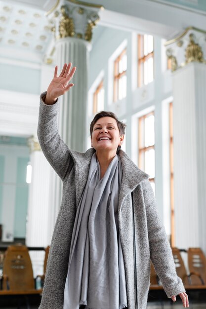 Femme souriante à coup moyen saluant