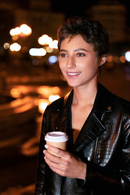 Femme souriante de coup moyen avec une tasse de café