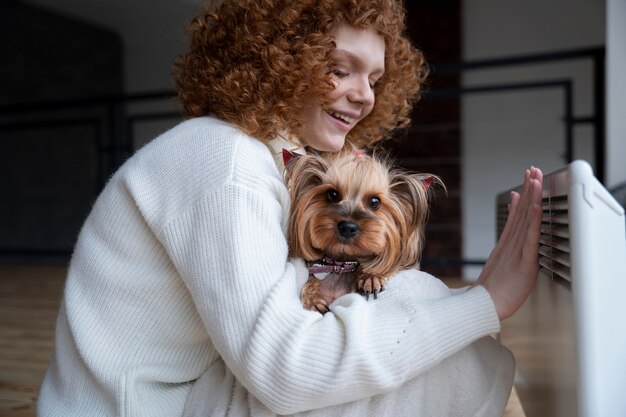 Femme souriante à coup moyen tenant un chien mignon