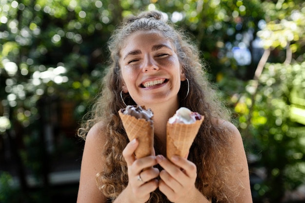 Femme souriante à coup moyen tenant des glaces