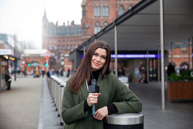 Femme souriante à coup moyen tenant un microphone