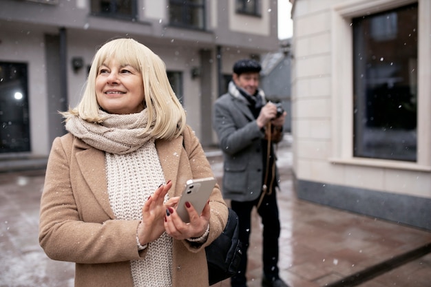 Femme souriante à coup moyen tenant un smartphone