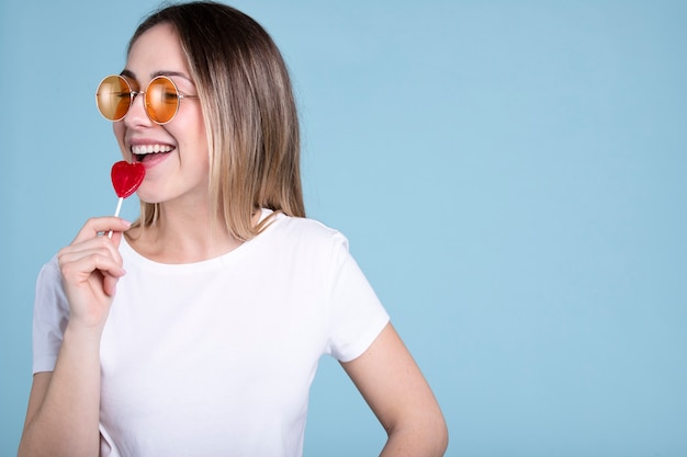 Femme souriante à coup moyen tenant une sucette