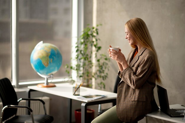 Femme souriante de coup moyen tenant une tasse