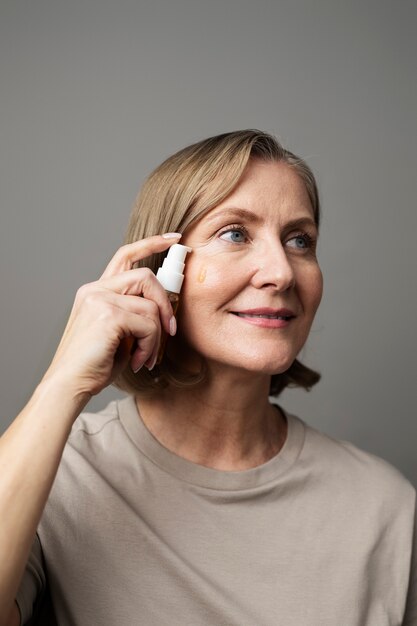 Femme souriante à coup moyen utilisant du sérum