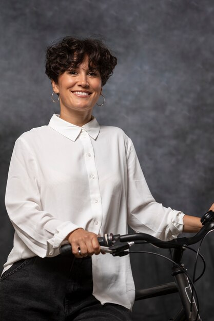 Femme souriante de coup moyen avec vélo
