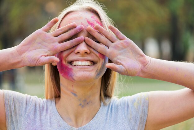 Femme souriante couvrant ses yeux au festival