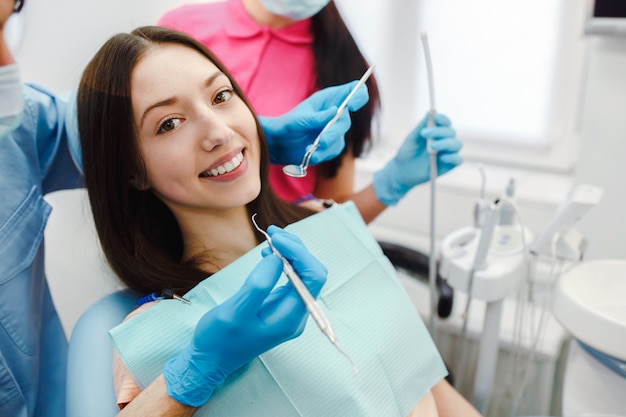 Femme souriante dans la chaise de dentiste