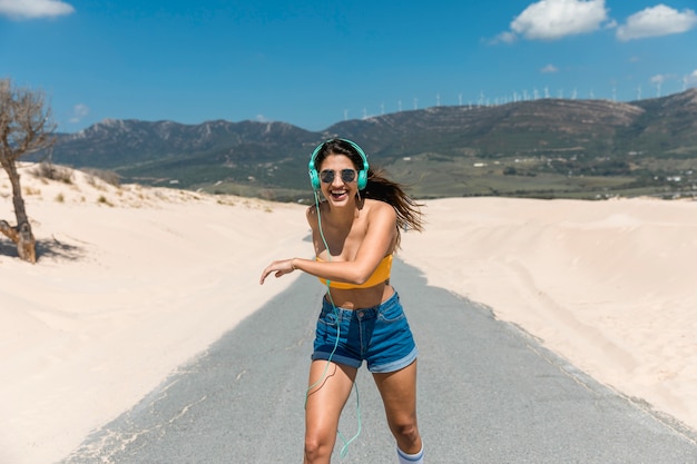 Femme souriante dans les écouteurs de patinage