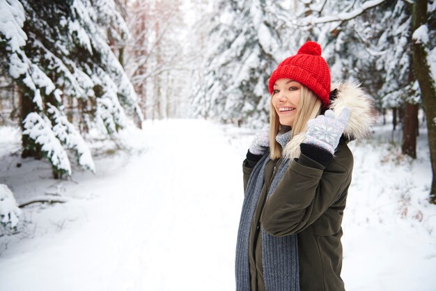 Femme souriante dans la forêt d'hiver