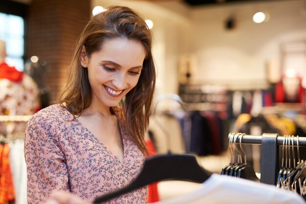 Photo gratuite femme souriante dans le magasin de vêtements