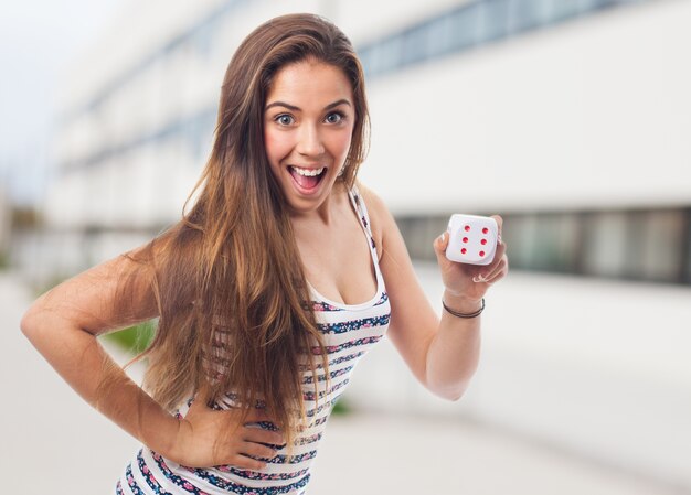 Femme souriante avec un dé à la face des six