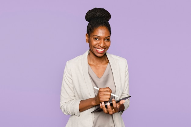 Photo gratuite femme souriante, écrivant des notes sur un appareil numérique de la tablette