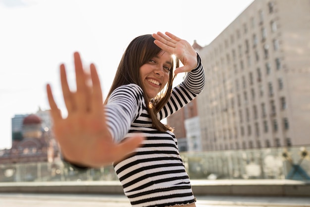 Femme souriante faible angle posant à l'extérieur