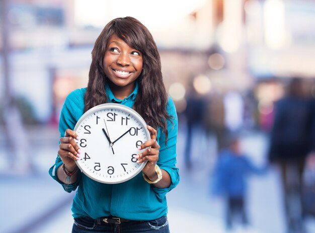 Femme souriante avec une grande horloge