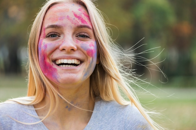 Femme souriante heureuse montre son visage coloré