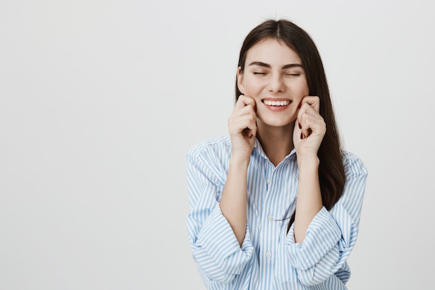 Femme Souriante Insouciante Tirant Ses Propres Joues Et Riant