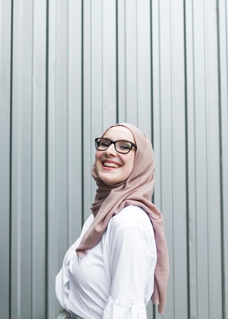 Femme souriante avec des lunettes et un hijab