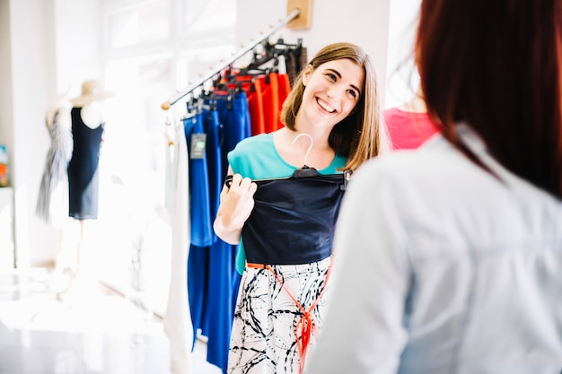 Femme souriante montrant une nouvelle robe