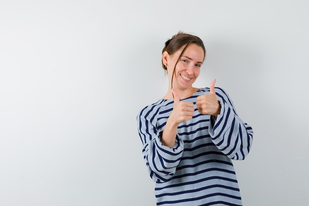 La femme souriante montre un geste parfait avec les pouces sur fond blanc