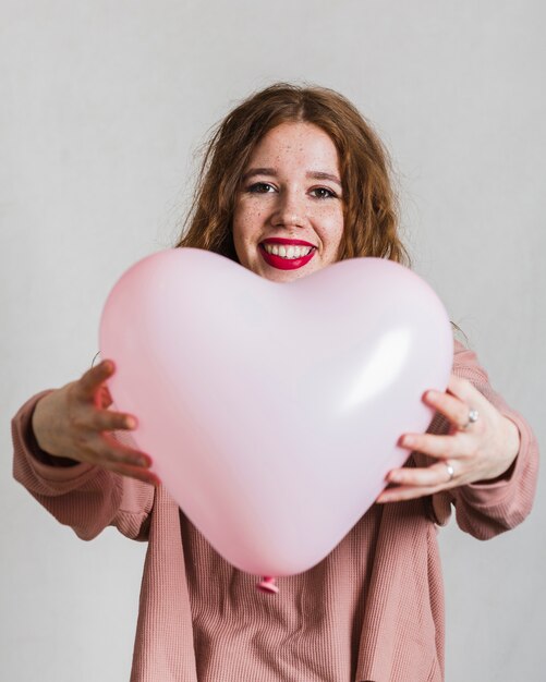 Femme souriante offrant un ballon