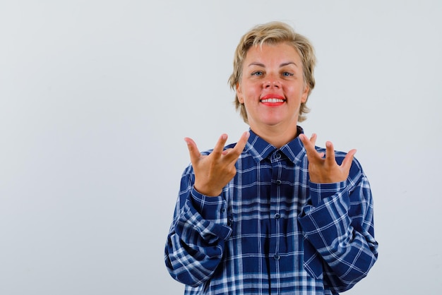 Photo gratuite femme souriante ouvrant ses mains sur fond blanc