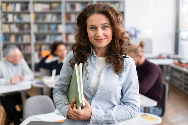 Photo gratuite femme souriante de plan moyen à la bibliothèque