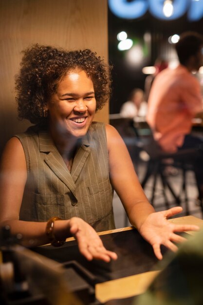 Femme souriante de plan moyen discutant