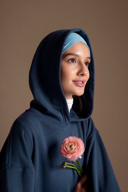 Femme souriante de plan moyen avec une fleur