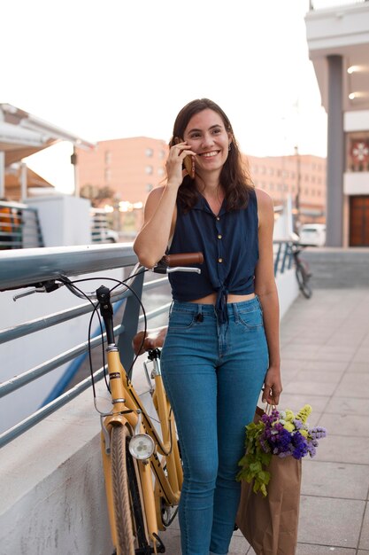 Femme souriante de plan moyen parlant au téléphone