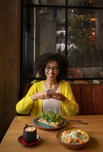 Femme souriante de plan moyen prenant des photos