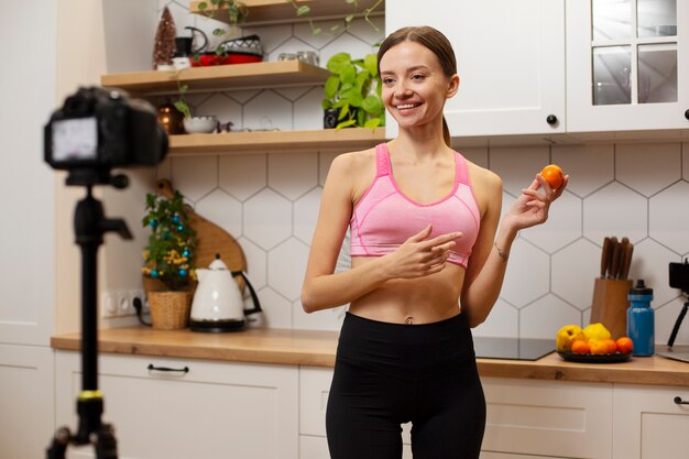 Femme souriante de plan moyen tenant des fruits