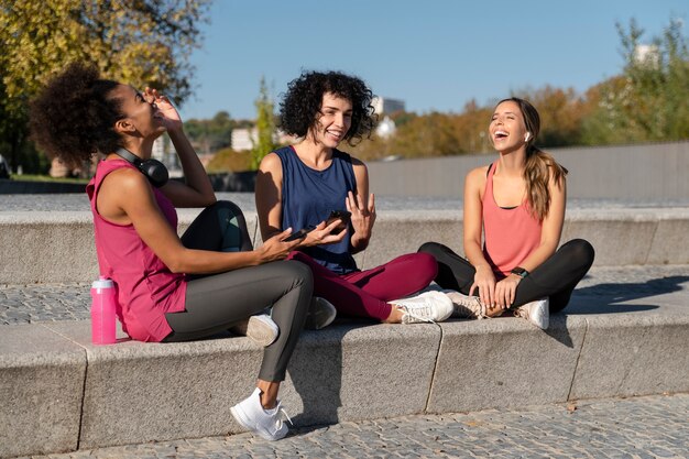 Femme souriante de plein coup assise dans les escaliers