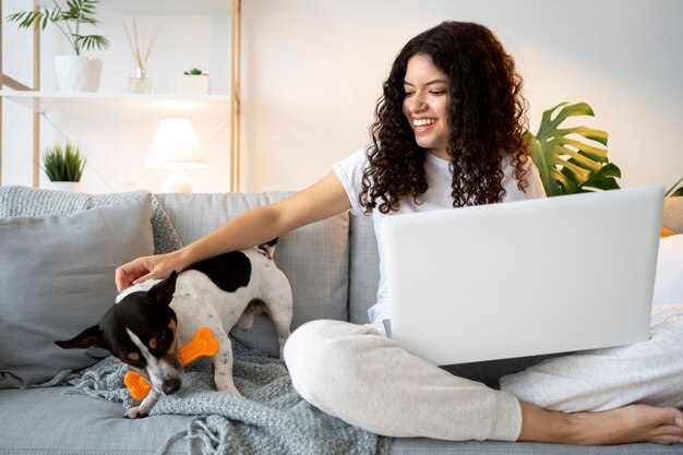 Femme souriante de plein coup sur le canapé