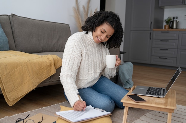 Femme souriante pleine coup tenant une tasse