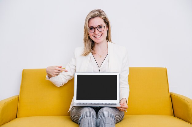 Femme souriante pointant sur ordinateur portable