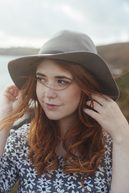 femme souriante portant un chapeau dans la nature