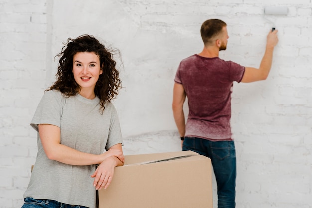 Femme souriante posant près de l&#39;homme qui travaille