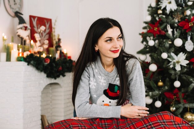 Femme souriante près d&#39;un arbre de Noël