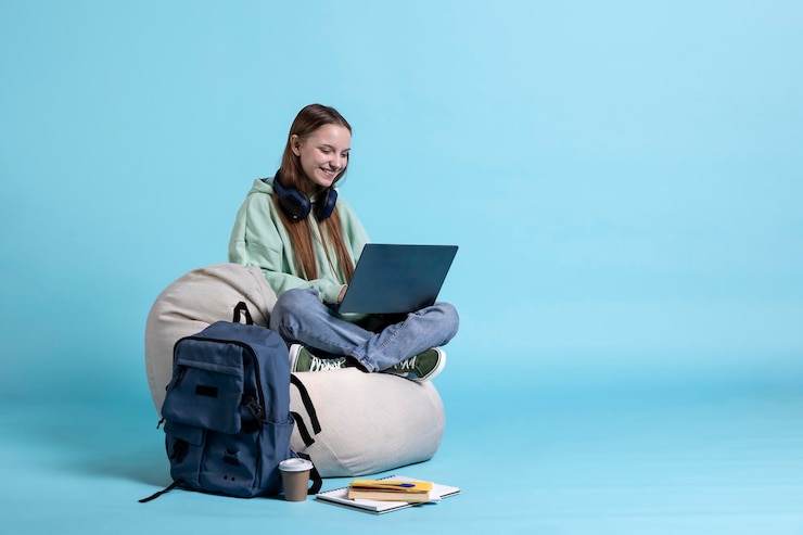 Photo gratuit une femme souriante qui fait défiler son ordinateur portable pour consulter les réseaux sociaux.