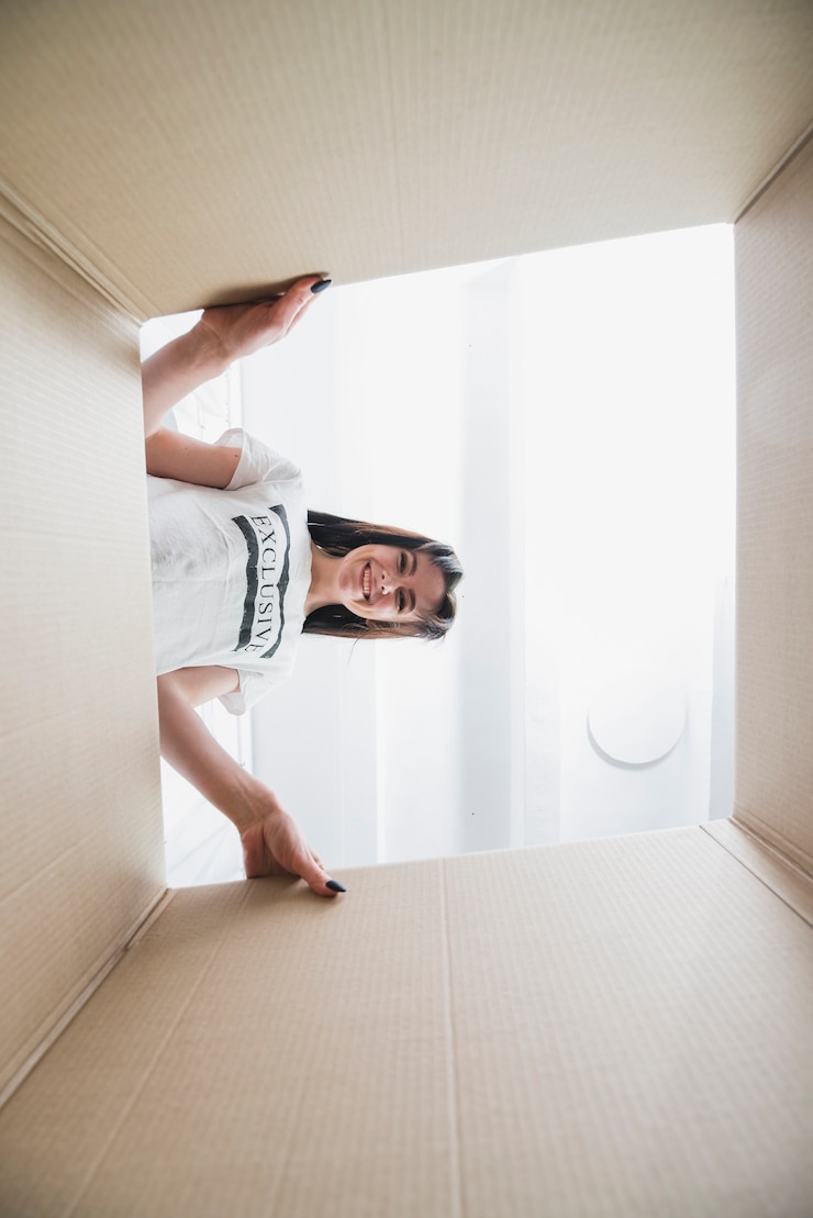 Photo gratuit femme souriante regardant à l'intérieur de la boîte