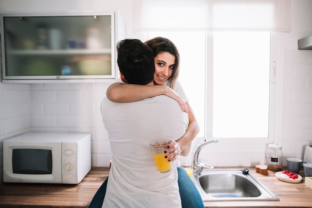 Photo gratuite femme souriante, serrant l'homme dans la cuisine