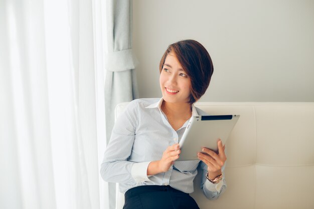 Femme souriante avec une tablette dans les mains